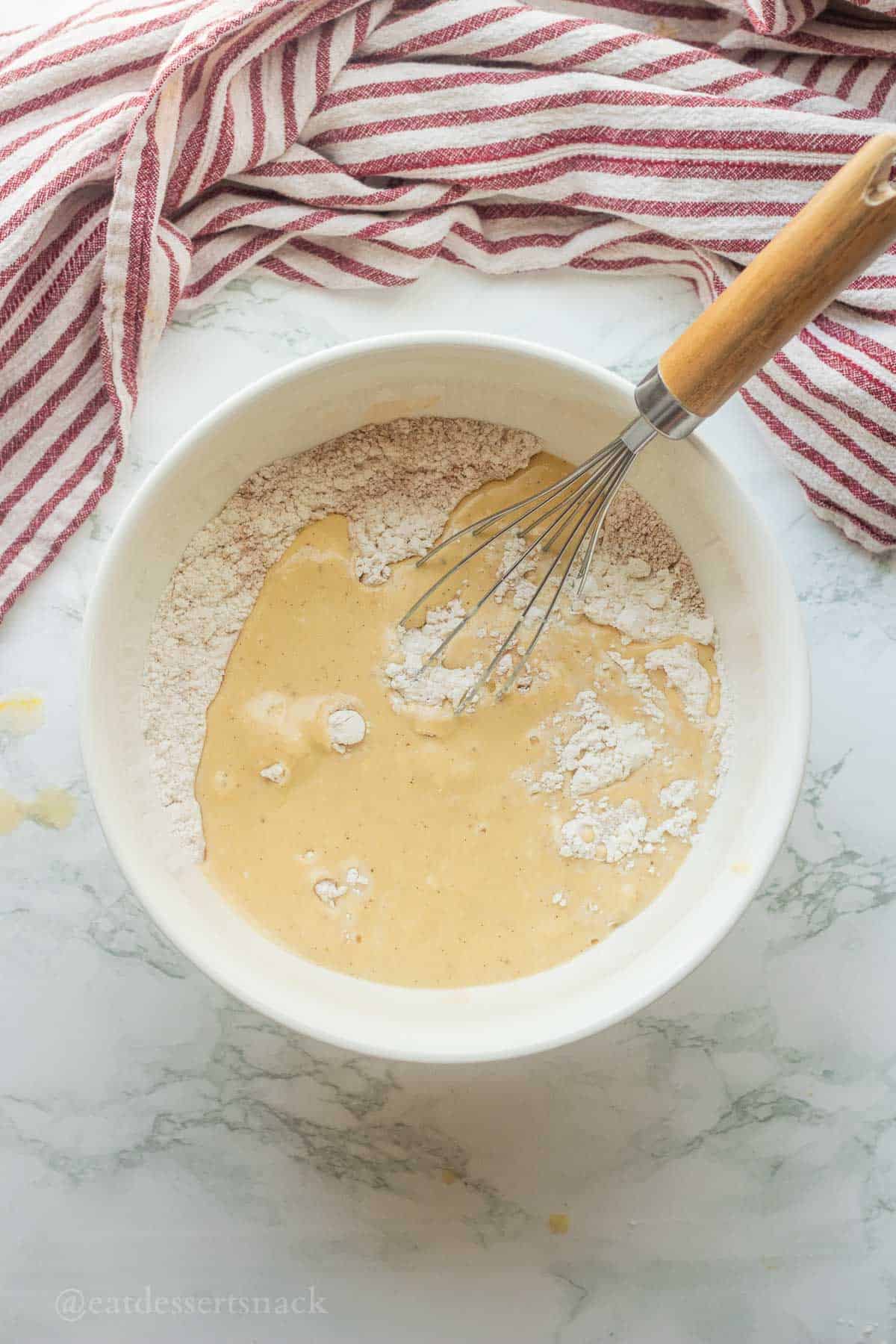 Mixing wet ingredients into dry ingredients with whisk.