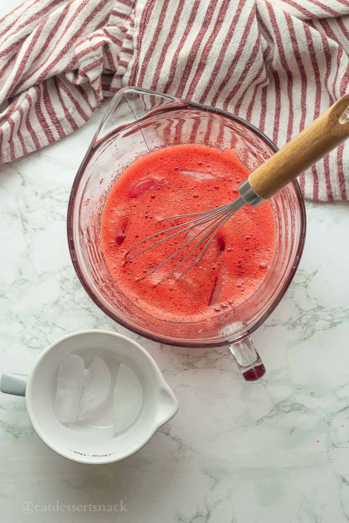 Ice in jello mixture with whisk.