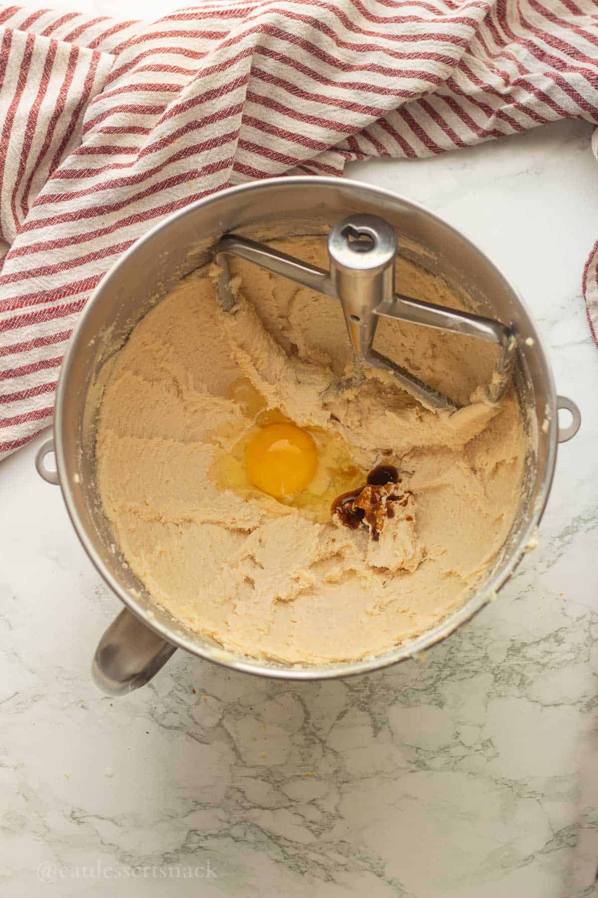 Egg and vanilla in creamed butter in mixing bowl.