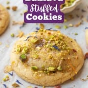 Baked baklava cookie brushed with honey on pan with pistachios and edible flower petals on top.