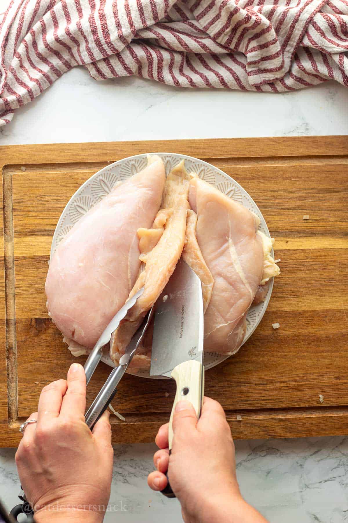 Slicing chicken breast with knife.