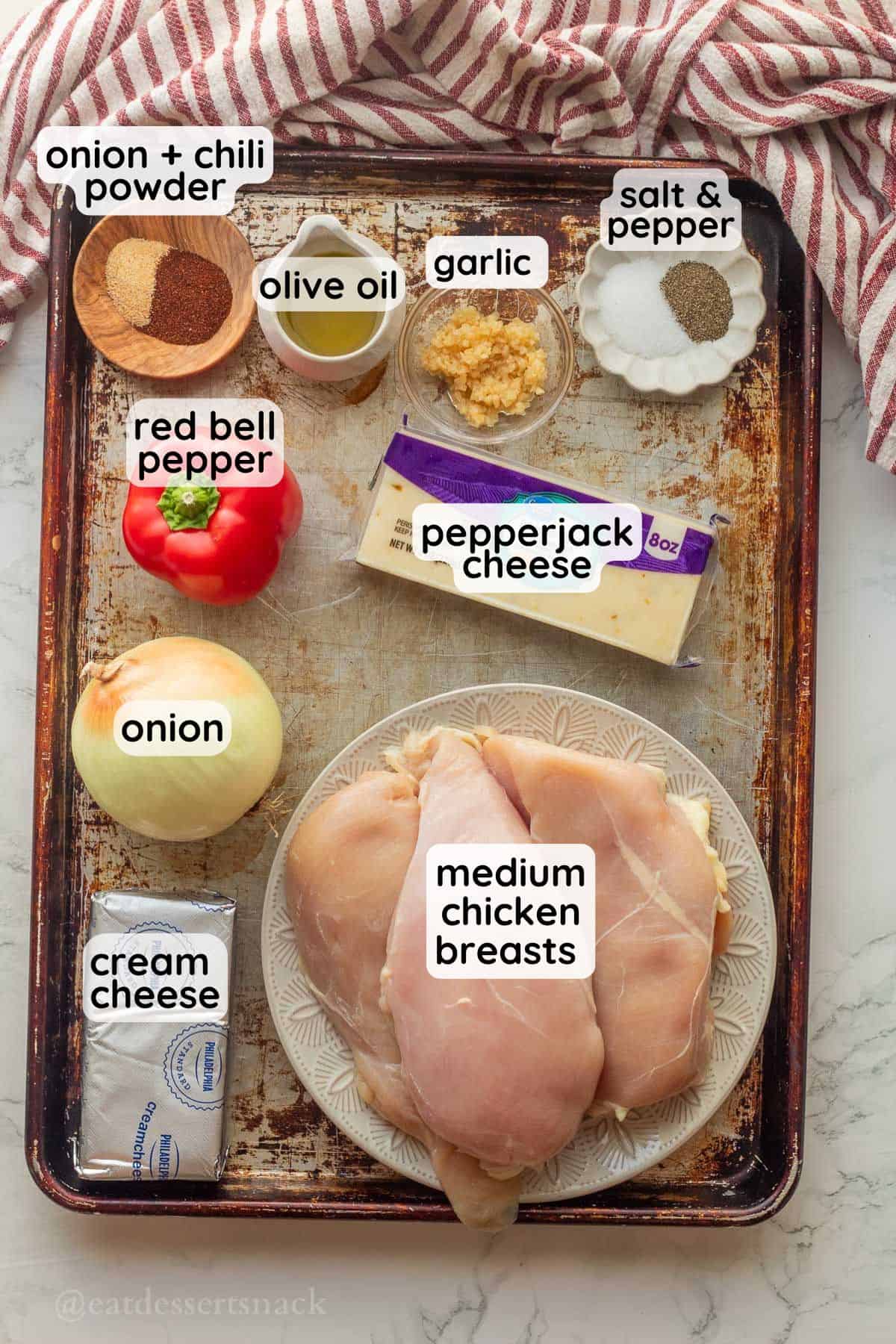 Labeled ingredients for Pepperjack Stuffed Chicken in glass dishes on a baking pan.