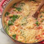 Tortellini white bean tomato soup in pot with spinach and cheese.