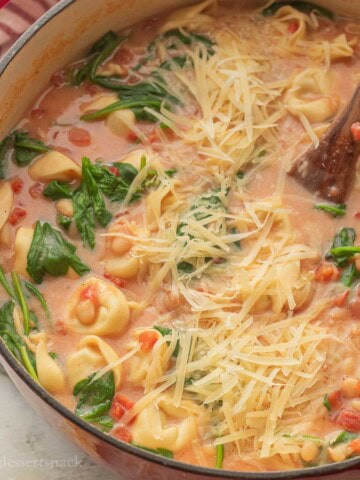 Tortellini white bean tomato soup in pot with spinach and cheese.
