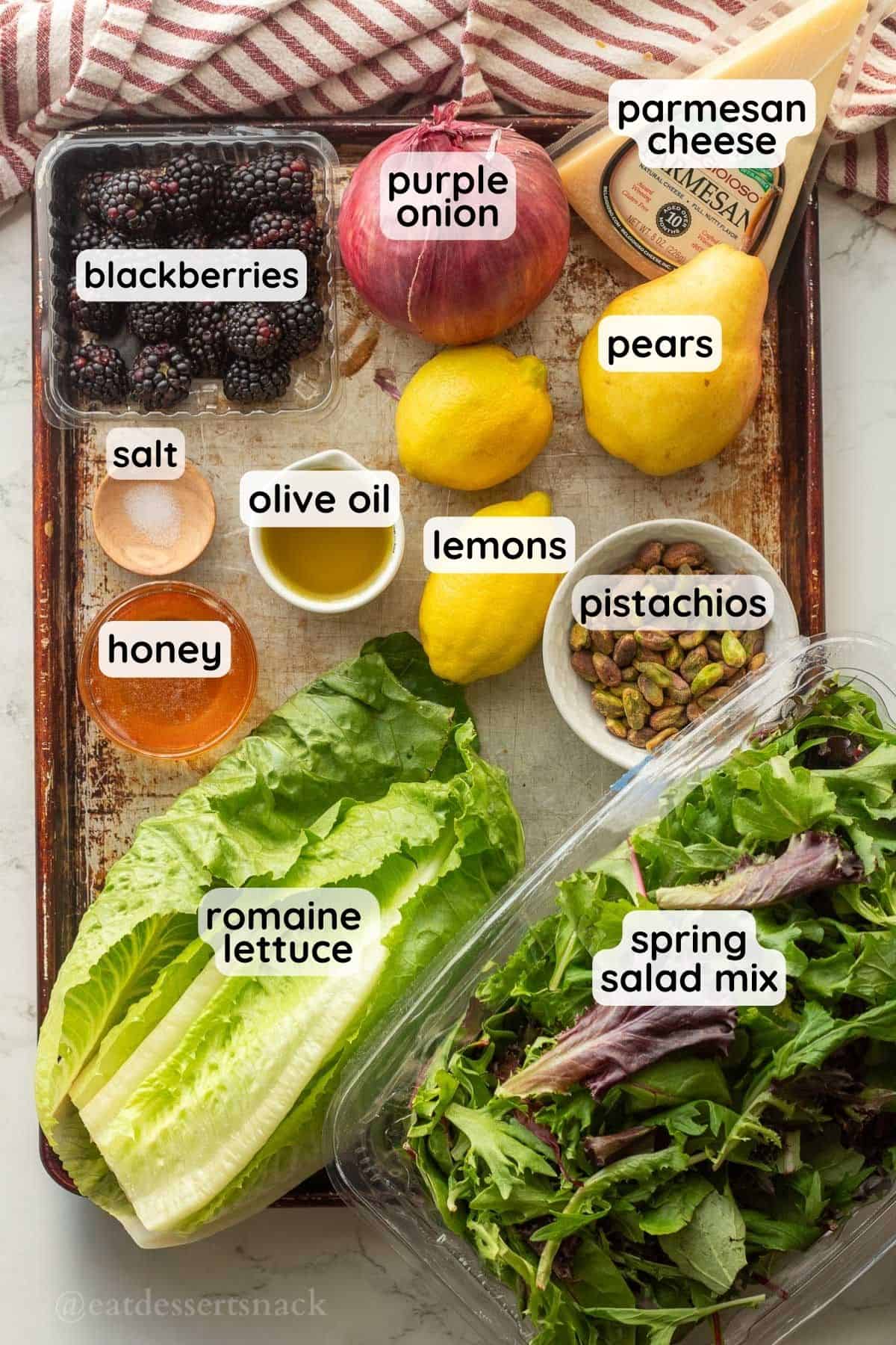 Glass bowls with labeled ingredients for blackberry pear salad on metal baking tray.