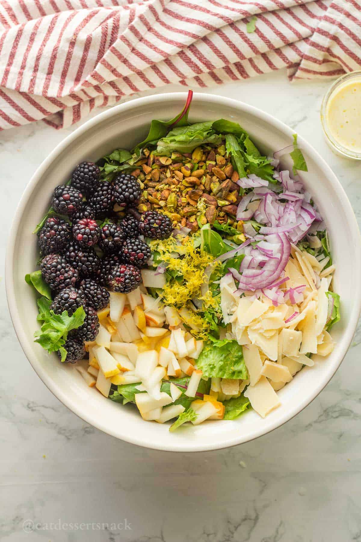 Ingredients separated in a bowl for blackberry pear salad.