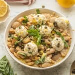 Butter bean salad with ricotta in bowl with basil.