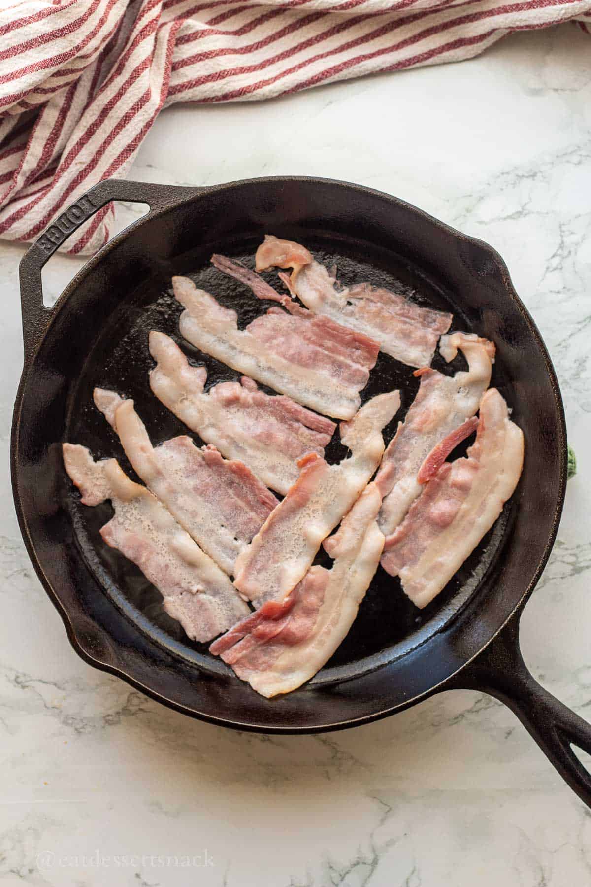 Cooking bacon in frying pan.