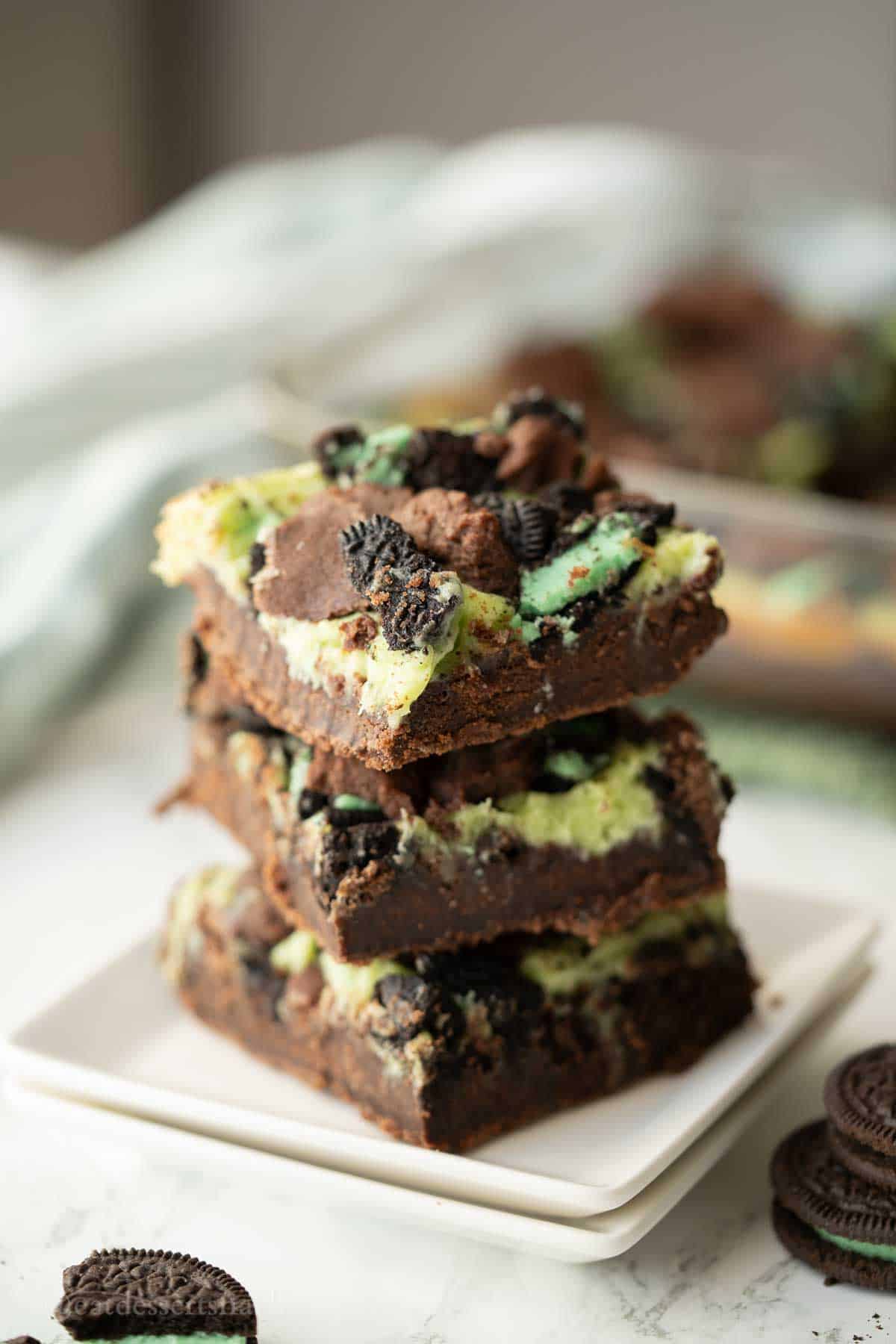 Stack of baked mint cheesecake brownies.