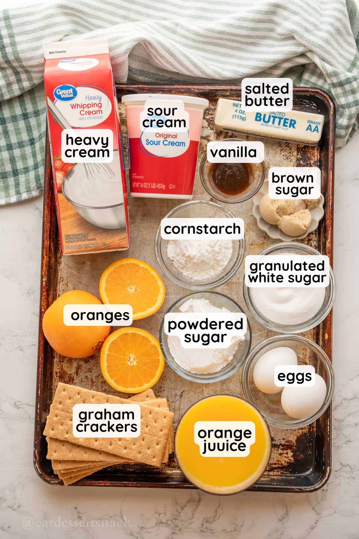 Labeled ingredients for orange pie in glass dishes on metal pan.