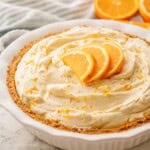 Orange pie with slices on top in pie pan.