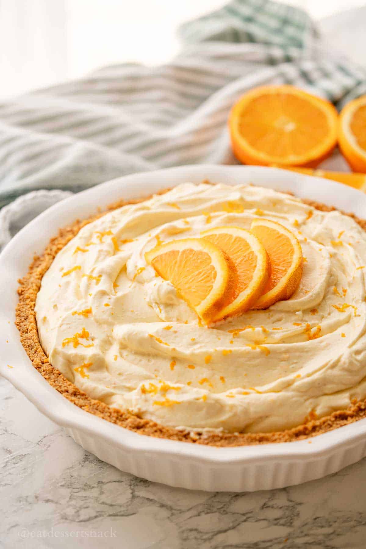 Orange pie with slices on top in pie pan.