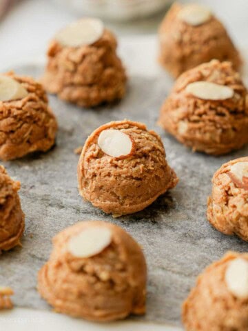 Almond butter protein bite on marble with almond slice.